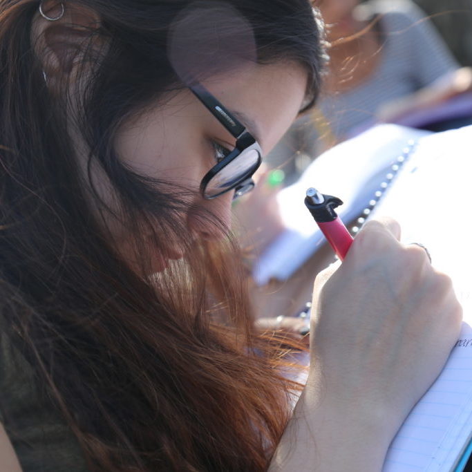 Teen engaged in writing in a notebook