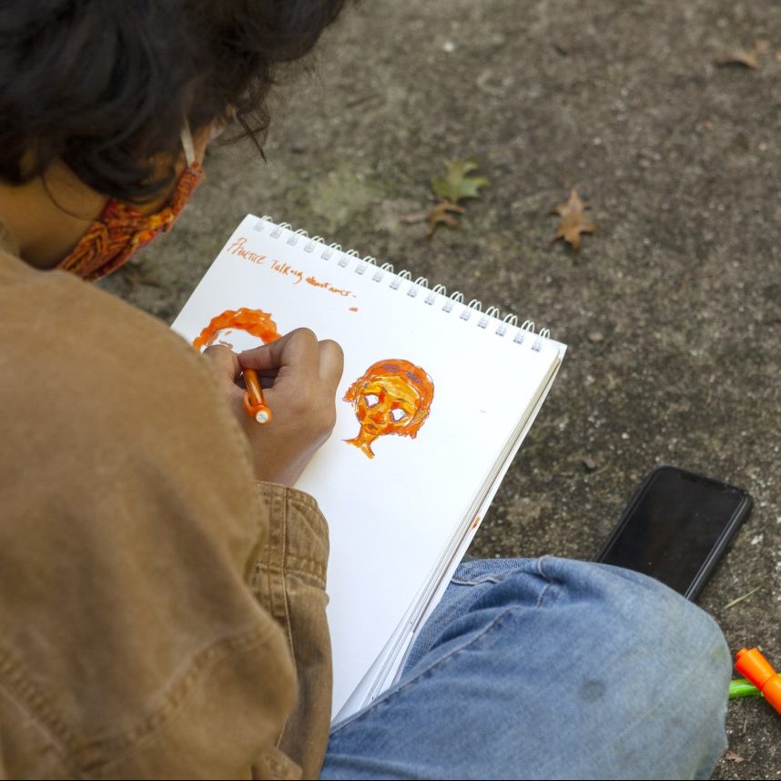 Teenager drawing faces with markers